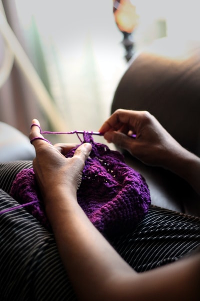 缝制紫色纺织品的妇女